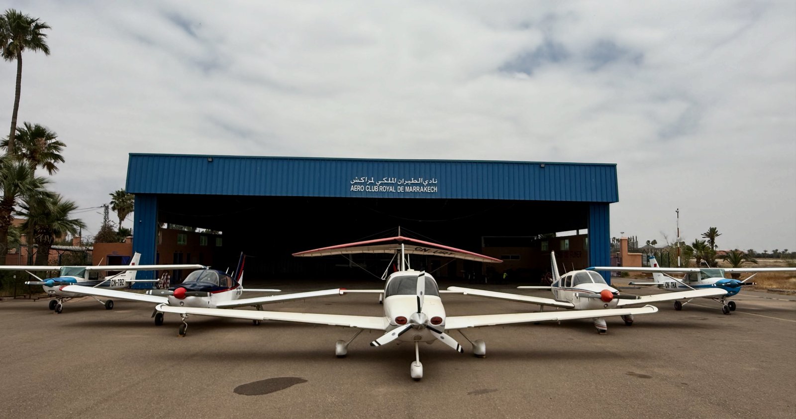 Le hangar bleu de l'Aéroclub Royal de Marrakech avec les avions du club alignés devant