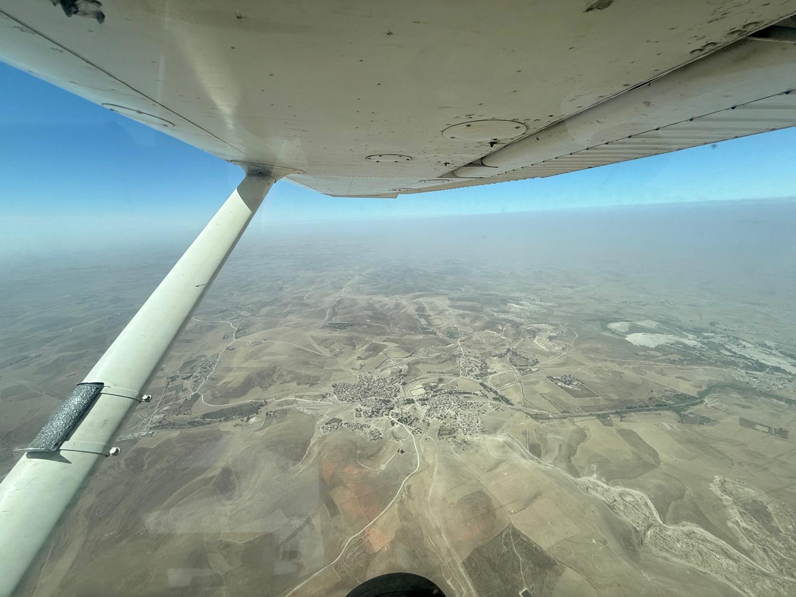 L'aile d'un avion du club au-dessus des plaines autour de Marrakech